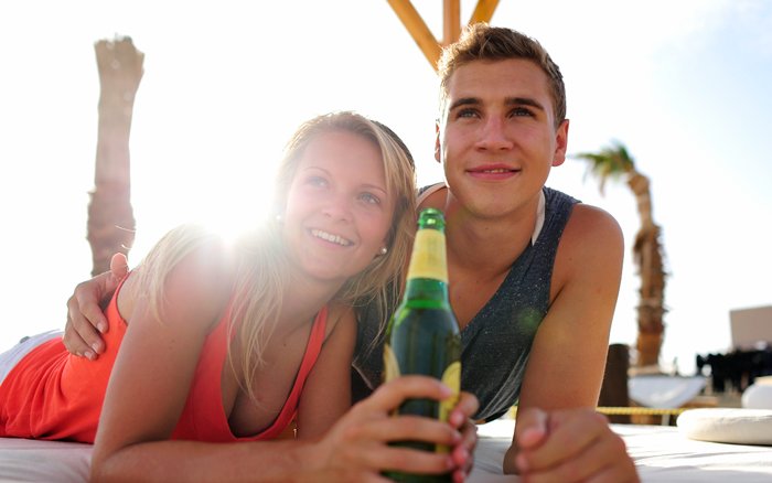 A young couple enjoying a relaxing moment with a cold drink at the beach of The Breakers Somabay.